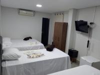 Dos camas en una habitación con dos perros. en Hotel Serrano, en Paracatu