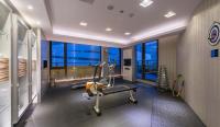 a room with a gym with a treadmill and large windows at Forward Hotel Taipei Nangang in Taipei