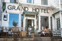 Un grupo de personas sentadas afuera de un gran hotel. en Grand Hotel Lysekil, en Lysekil
