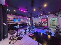 eine Bar mit Hockern in einem Zimmer mit lila Beleuchtung in der Unterkunft Huskies and Company in Pattaya