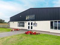 een wit gebouw met bloemen ervoor bij Riverside Holiday Park in Banks