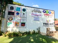 a wall with signs on it with a yard at Suites by Eco Hotels in El Nido