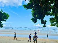 a group of people walking on the beach at Suites by Eco Hotels in El Nido