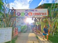 a person walking under a welcome to dogs district sign at Suites by Eco Hotels in El Nido