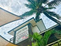 a building with a palm tree in front of it at Suites by Eco Hotels in El Nido