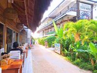 a person sitting at tables outside of a building at Suites by Eco Hotels in El Nido