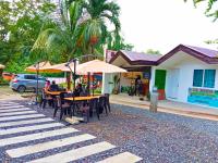 a group of people sitting at tables with umbrellas at Suites by Eco Hotels in El Nido