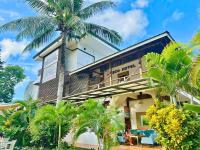 a building with a palm tree in front of it at Suites by Eco Hotels in El Nido