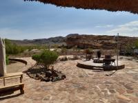 a patio with people sitting on the ground in a field at Hais Ra Tented Campsite in Khorixas