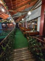 a restaurant with wooden tables and green carpet at Hotel Las Cañas in Baños