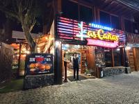 a man standing outside of a restaurant at night at Hotel Las Cañas in Baños