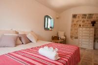 Posteľ alebo postele v izbe v ubytovaní HELLOAPULIA Trulli Santa Maria dei Grani - Private Pool and large garden for furry friends