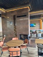 Kulm Resort في Radanj: غرفة طعام بها موقد وطاولات وكراسي