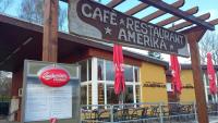 Un restaurante con un cartel delante de un edificio. en Camping Amerika, en Františkovy Lázně