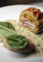 Un trozo de comida en un plato con una hoja verde. en Villa Bordone - Country House, en Bric Gallo