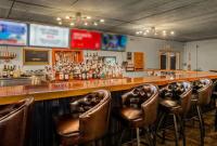 un bar con sgabelli da bar in pelle marrone in una stanza di Sunny Sebring Getaway a Sebring