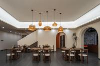une salle à manger avec des tables et des chaises en bois dans l'établissement Island Diary Hillside Private Hot Spring Manor, à Dapengcheng