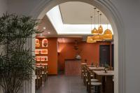 une arche menant à un restaurant avec des tables et des chaises dans l'établissement Island Diary Hillside Private Hot Spring Manor, à Dapengcheng