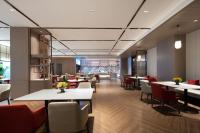 um restaurante com mesas brancas e cadeiras vermelhas em Echeng Hotel Chengdu Chunxi Road Taikoo Li em Chengdu