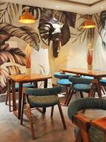 布巴内什瓦尔The Divan的一间设有桌椅的房间,配有大象壁画
