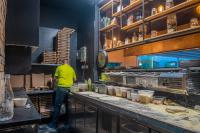 een man die in een keuken staat en eten klaarmaakt bij Camping Merendella in San-Nicolao