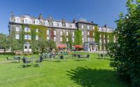 un gran edificio con mesas y sillas en el césped en Old Swan Hotel, en Harrogate