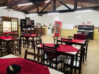 een restaurant met rode tafels en stoelen en een rode machine bij Estância da vida Hotel e laser in Engenheiro Paulo de Frontin