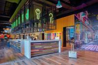 a restaurant with a counter with neon signs on the wall at Moxy Ningbo Old Bund in Ningbo