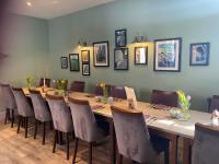 een lange houten tafel en stoelen in een kamer bij The Royal George in Cottingham