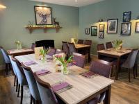 een restaurant met houten tafels en stoelen met bloemen erop bij The Royal George in Cottingham