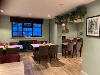 een eetkamer met tafels en stoelen en een raam bij The Royal George in Cottingham