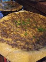 a pizza sitting on top of a wooden cutting board at Colors Hostal in Boquete