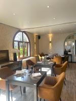 een eetkamer met tafels en stoelen in een restaurant bij Sure Hotel by Best Western Saint-Quentin Ouest Le pot d étain in Holnon