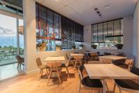 Hotel Sorli Emocions في Vilassar de Dalt: مطعم به طاولات وكراسي ونوافذ كبيرة