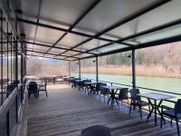 een overdekt terras met tafels en stoelen naast het water bij Ağva Capella Hideaway Hotel in Sile