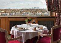 a table in a restaurant with a view of a city at Pavillon Henri IV Hotel Restaurant Gastronomique Terrasse in Saint-Germain-en-Laye