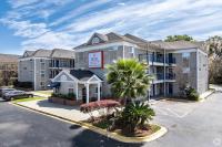 un gran edificio de apartamentos con una palmera en un aparcamiento en Siegel Select Orange Park, en Orange Park