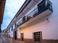 a white building with a balcony on a street at Novotel Cusco in Cusco