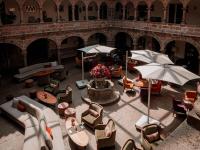 an outdoor patio with chairs and tables and umbrellas at Novotel Cusco in Cusco