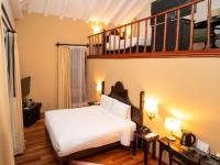 a hotel room with a white bed and two tables at Novotel Cusco in Cusco