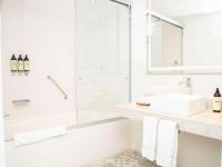 a white bathroom with a shower and a sink at Novotel Cusco in Cusco