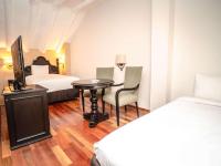 a hotel room with a bedroom with a table and a bed at Novotel Cusco in Cusco
