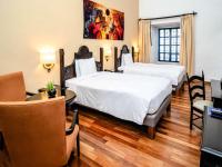 a hotel room with two beds and a flat screen tv at Novotel Cusco in Cusco