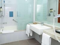 a white bathroom with a sink and a shower at Novotel Cusco in Cusco