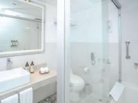 a white bathroom with a sink and a shower at Novotel Cusco in Cusco