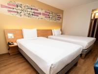 two beds in a hotel room with white sheets at Novotel Cusco in Cusco