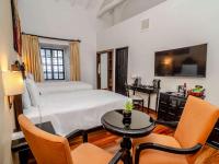 a bedroom with a bed and a table and chairs at Novotel Cusco in Cusco