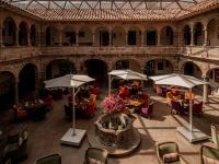 an outdoor patio with tables and chairs and umbrellas at Novotel Cusco in Cusco