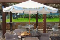 a table and chairs with an umbrella on a patio at Resort QSB - Um novo padrão de conforto e lazer no coração da cidade in Pirenópolis