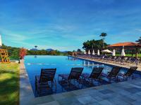 a pool with chairs and umbrellas in a resort at Resort QSB - Um novo padrão de conforto e lazer no coração da cidade in Pirenópolis